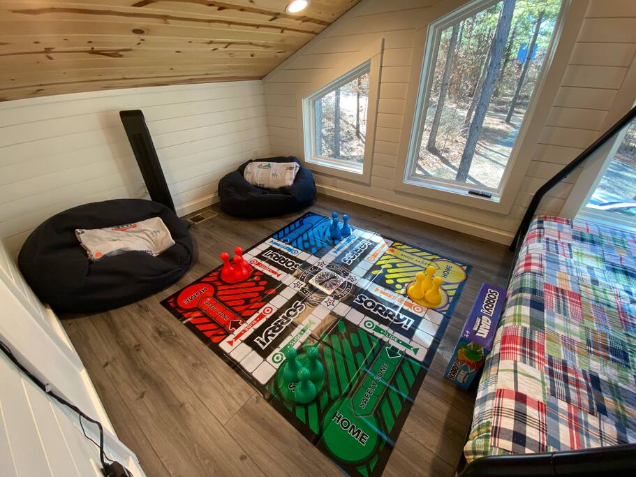Cozy game room with giant 'SORRY!' board, colorful pieces, and relaxing bean bags.