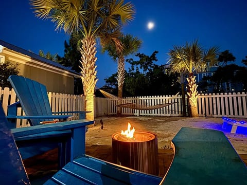 Moonlit backyard escape: fire pit, hammock, and glowing palms for ultimate relaxation.