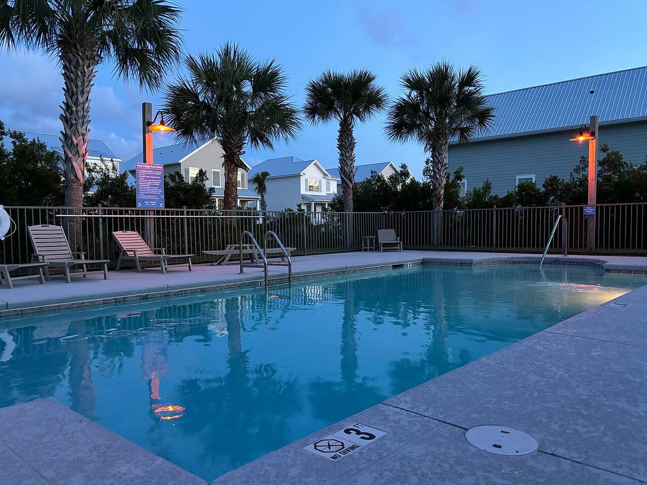 Relax by a serene palm-lined pool at sunset in a peaceful beachside vacation rental.