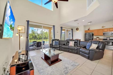 The main sitting room. An open concept attached to the kitchen with direct access to the screened in lanai. Featuring a 65 inch smart tv.