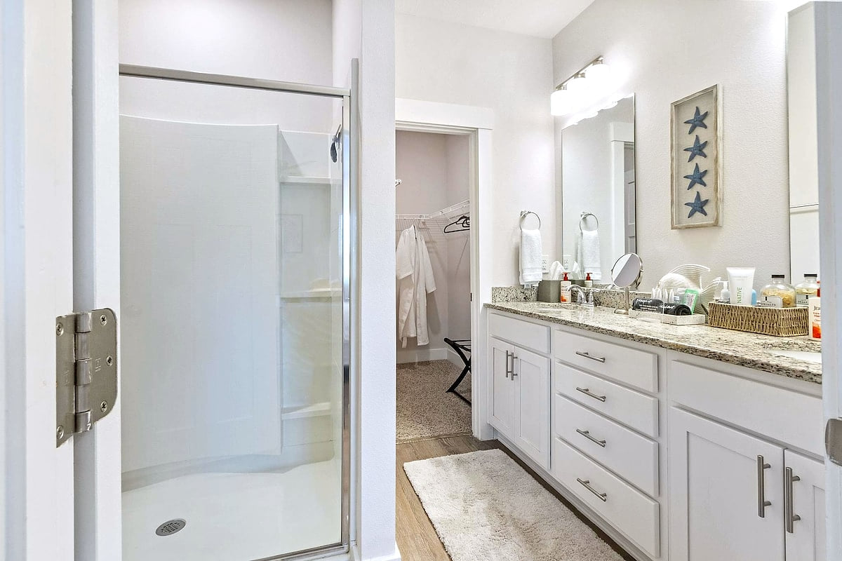 Bright bath: double vanity, walk-in shower, and closet with robes.