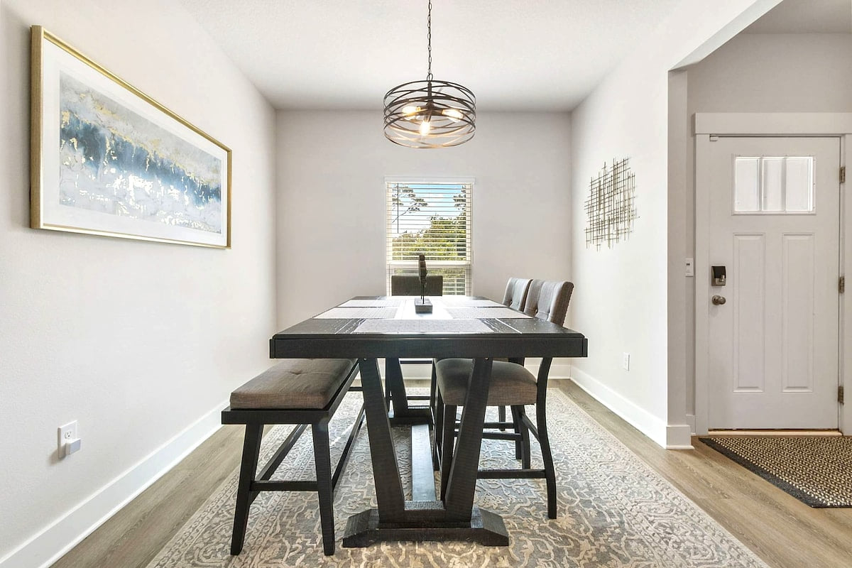 Sunny dining nook with high-top table, chic pendant, and cozy bench seating