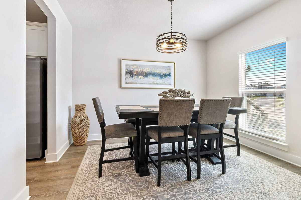 Sunlit dining room for six with modern pendant and cozy patterned rug