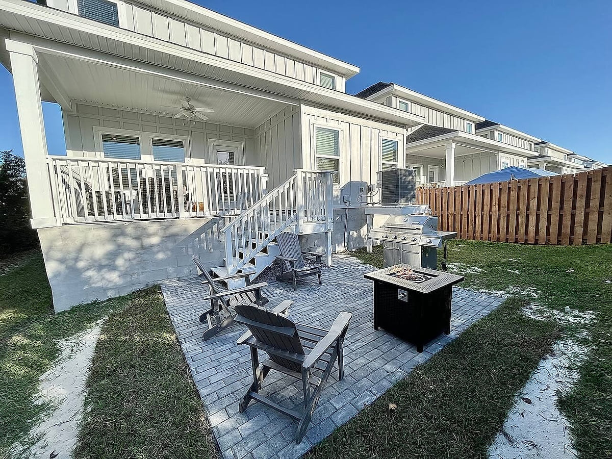 Fenced backyard with fire pit, grill, and a breezy covered porch.