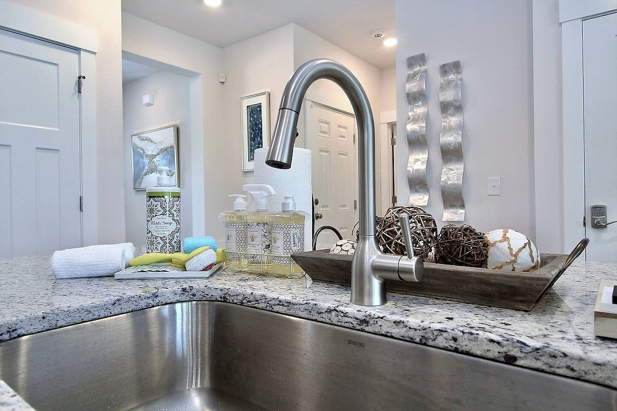 Modern granite island with pull-down faucet and stocked essentials