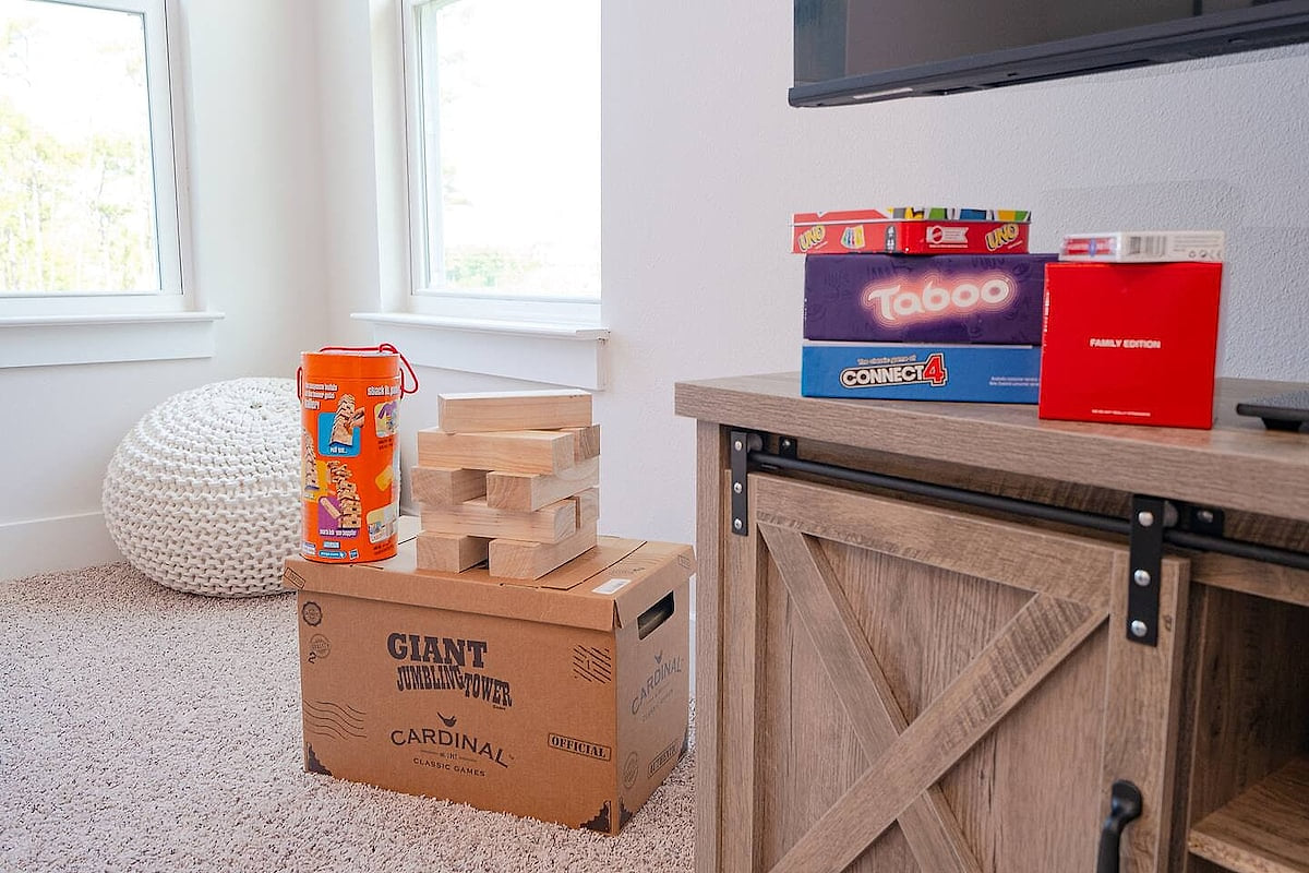 Bright family game nook with TV, barn-door console, and jumbo Jenga