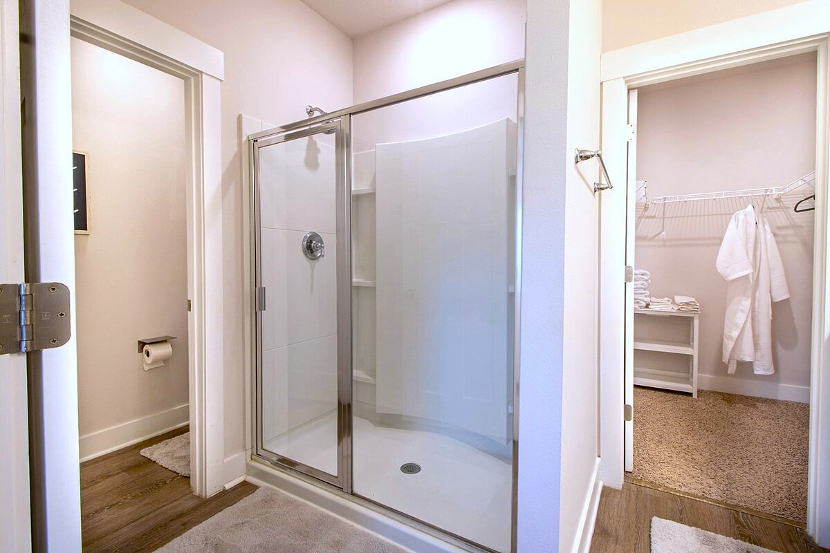 Bright bath with glass shower, private WC & walk-in closet
