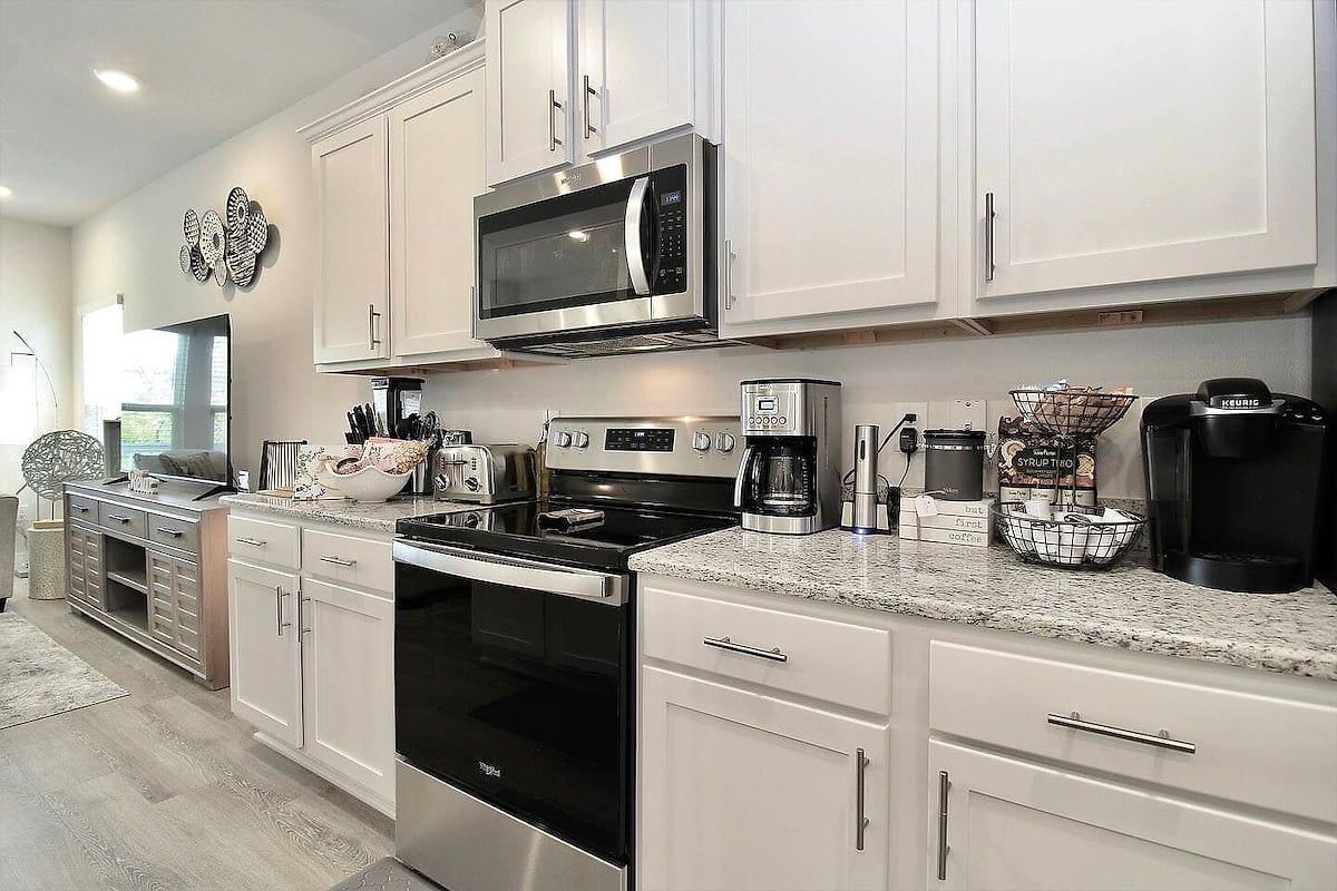 Bright chef’s kitchen with stainless suite and stocked coffee bar