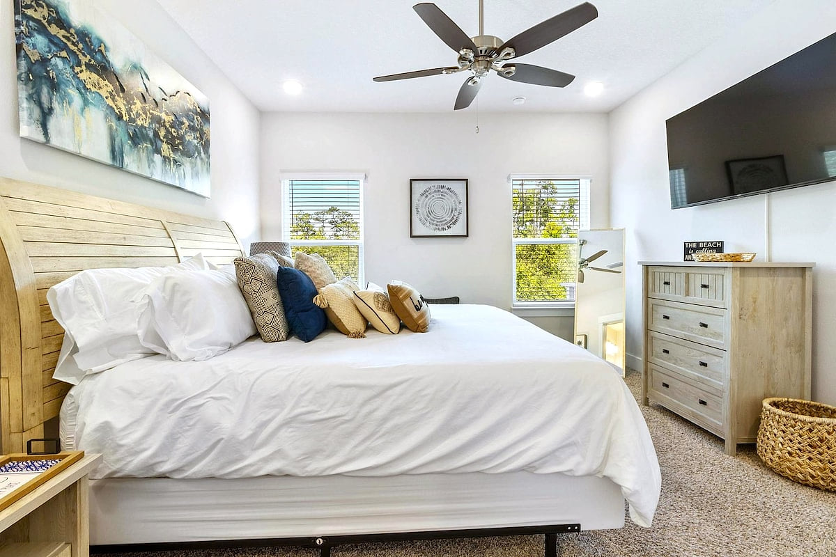 Sunny king suite with smart TV, ceiling fan, and cozy coastal touches