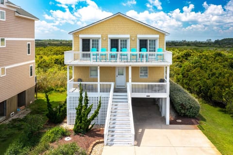 Welcome to Reel Salt OBX! Your vibrant coastal retreat with signature turquoise adirondack chairs, designer landscaping, and a front-row seat to the best of Nags Head.