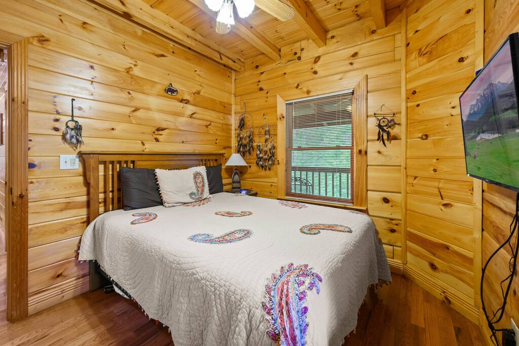 First downstairs bedroom features a queen bed.