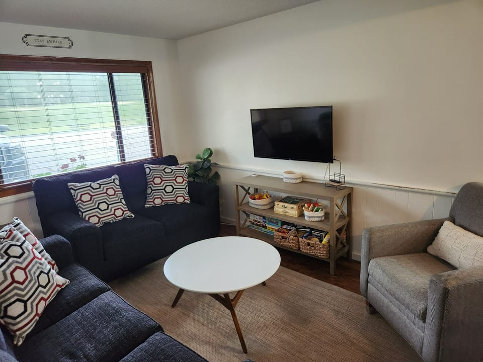 Livingroom with Couch, loveseat and chair. We have Roku enabled TVs for you to log into your favorite streaming services. We also have books, toys and boardgames for the whole family.