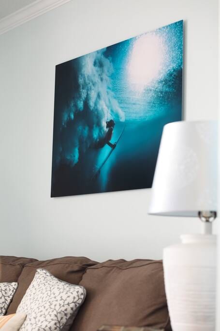 You'll see art throughout our home. Surfer girl is one of my favorite pieces. Speaking of surfing, it's a thing on our island. Though conditions do fluctuate. Sometimes it's calm, sometimes it's Surf's Up! Also, we've replaced that brown sofa and cushions.