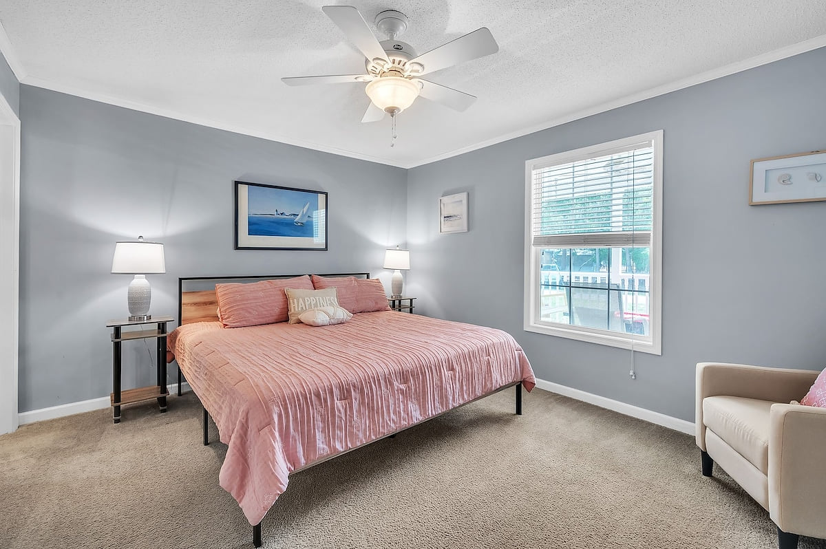 The main bedroom has a king size bed, a corner chair and a ROKU TV.  The bedside lamps include USB ports for mobile phone charging. 