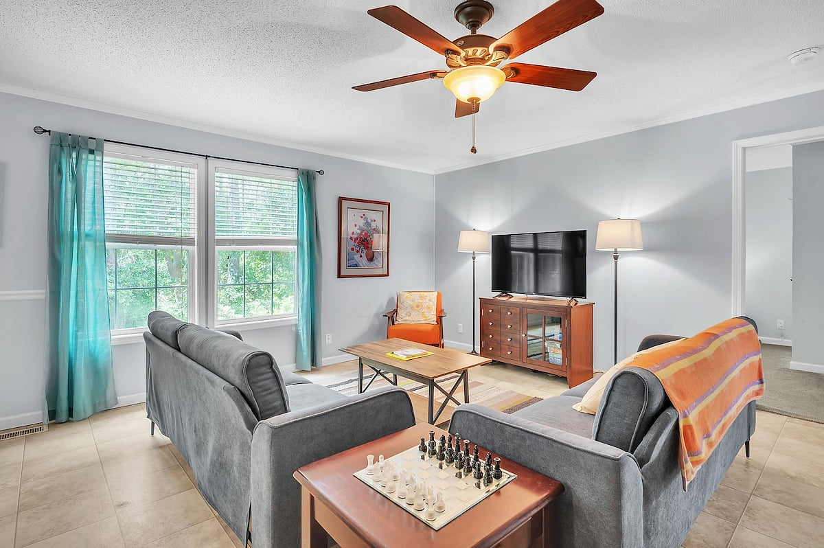 The living room seats seven comfortably, with additional seating at the high table and counter.