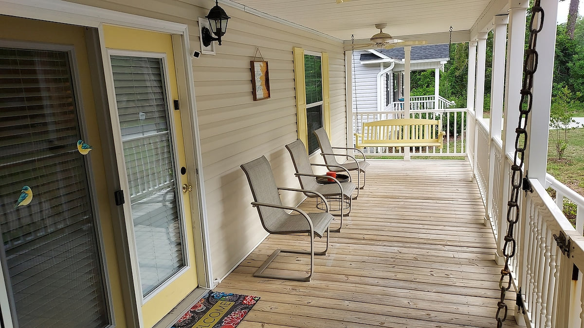 With two ceiling fans, two porch swings, and three deck chairs, the fenced-in front deck is cool and secure outdoor space to relax after a day at the beach.