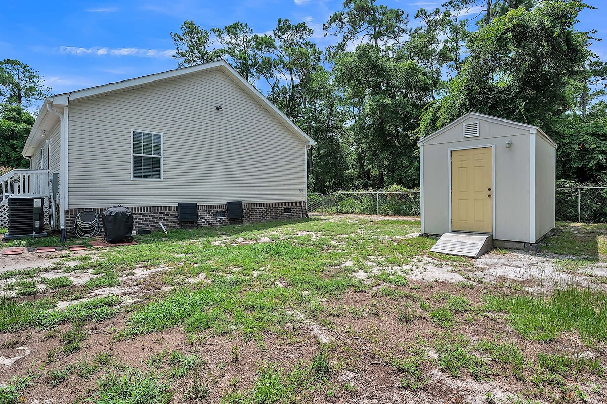 The fenced-in backyard is a great place for you dog to roam.  They can find shade along the house and shed, and you can fill a water dish with the hose there as well.  The charcoal grill and folding tables are also here.  