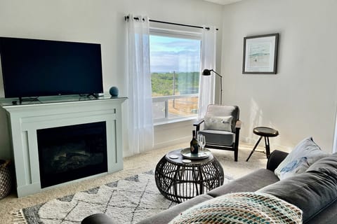 The bright and airy living room looks towards the ocean.