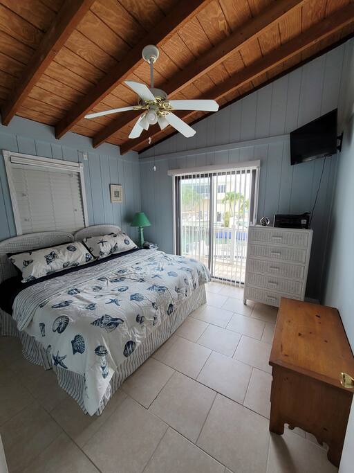 King Bedroom With Sliding Door to Deck, View of Canal. - Pool-2 HotTubs-Boat Lift-Easy Access to Gulf&Ocean - Summerland Key