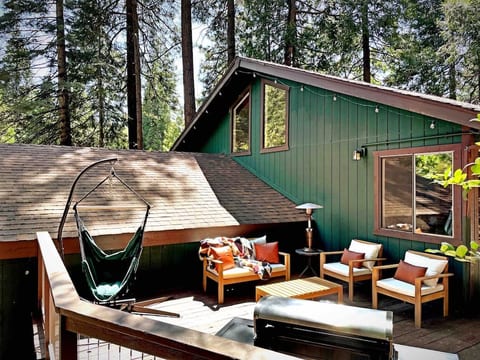 Featuring a deck in the backyard with seating, bbq, and a hammock to enjoy the beautiful forest setting