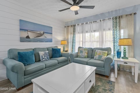 Bright coastal living space perfect for relaxing after a beach day! Enjoy comfortable seating, Smart TV entertainment, and an open layout designed for family time.