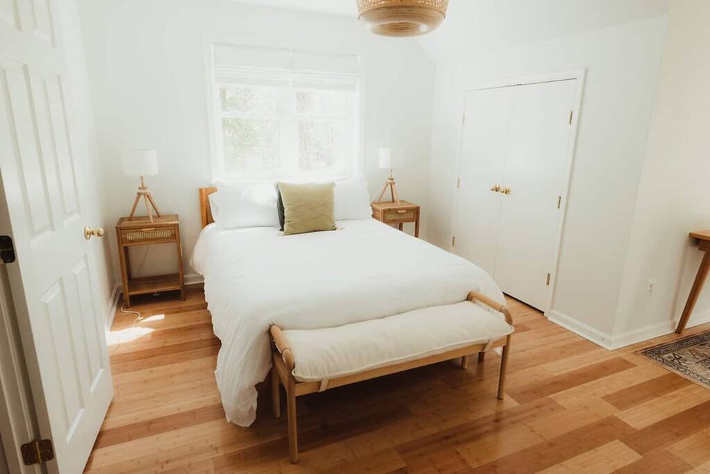 Upstairs bedroom with a queen bed, desk nook, and library. 