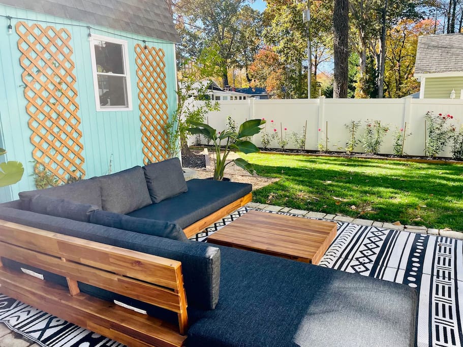 The backyard is an oasis featuring a large seating area and dining table. 