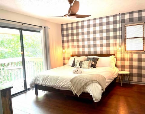 Primary bedroom with King bed. Sliding glass doors open up to the deck. It also has an en suite bath, tv, and an oversized closet (big enough to fit a pack and play!)