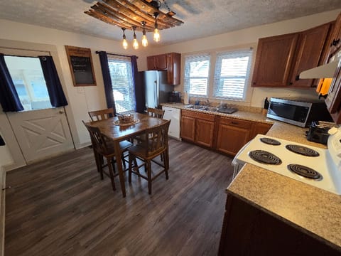 Fully stocked kitchen with plates/utensils/serving utensils, pots/pans, coffee maker and supplies.