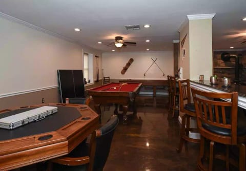 Game room includes pool table, ping pong table, shuffleboard, dart board, and poker table. Area includes bar top seating. Perfect area for a game night or football Sunday!