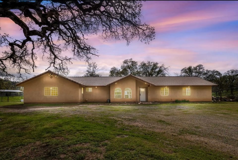 ET Ranch House surrounded by oak trees and misty meadows.