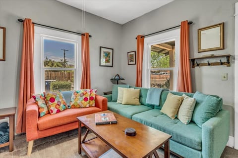 Sunny living room full of color, vintage windows and local art