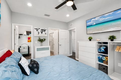 Cozy bedroom with single bunkbed, king sized bed, drawers for storage and smart TV. Ideal room for a family with kids or a group of friends. 