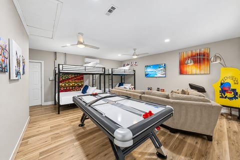 Ultimate game room with air hockey, arcade games, lounge seating, and bunk beds.