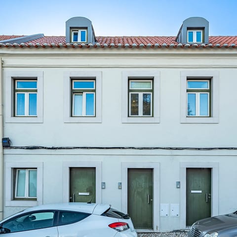 Charming Facade: Enjoy traditional Lisbon vibes with bright windows and a delightful green entrance!