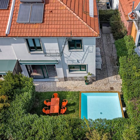 Outdoor Oasis: Dive into relaxation with a sparkling pool and vibrant dining set in lush greenery!