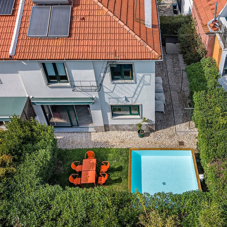 Outdoor Oasis: Dive into relaxation with a sparkling pool and vibrant dining set in lush greenery!