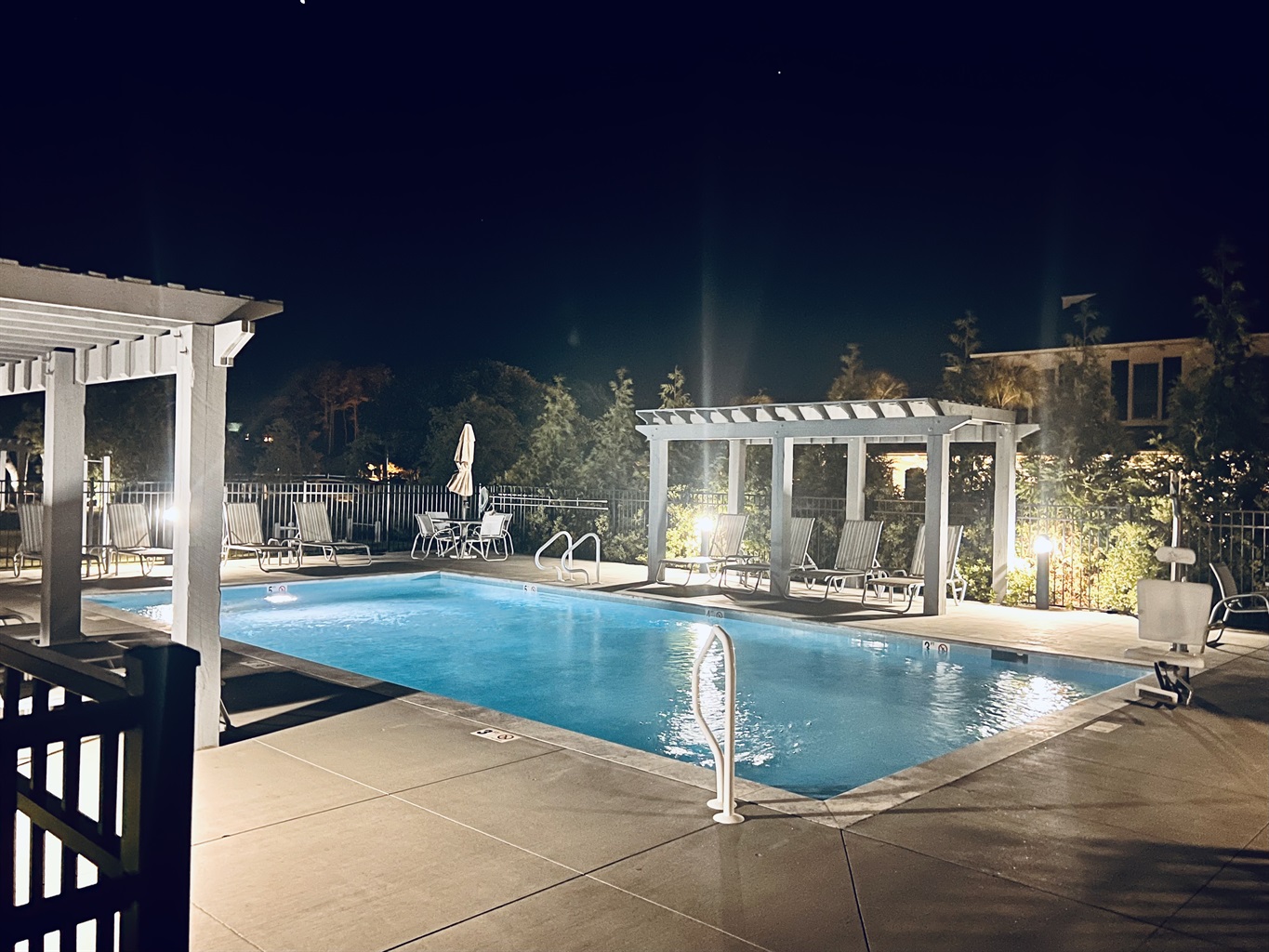 Pool steps from door lit up at night 