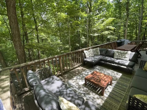 Large deck with comfortable sectional seating and dining set. A great place to relax. You will feel like you're in the trees!
