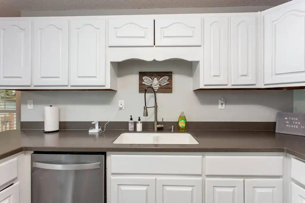 Dishwasher, tons of cabinets, and lots of counter space make this kitchen very user friendly! New solid surface Corian countertops. There's even a touchless phone charger that has a UV light disinfecting option available! - Pink Door Farmhouse - Ellijay