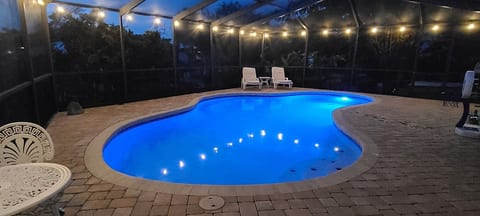 Our pool area lit by evening lights, offering a tranquil setting for a nighttime dip or poolside relaxation