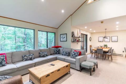 Open concept living room and dining room with cathedral ceilings, lots of light