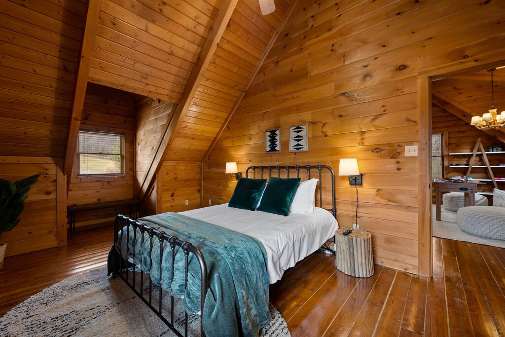 Upstairs queen-size bed in a spacious bedroom with sitting areas. Perfect space to relax and read.