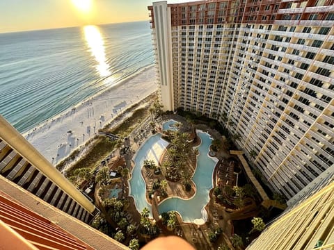 View of epic pool, tiki bar & grill, hot tub, and gulf from balcony