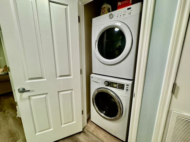 Washer and dryer located across from half bath in hall