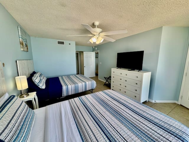 Front bedroom with two queen beds and private access to the main balcony through door on the right
