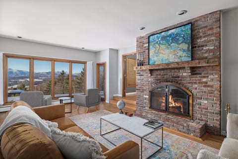 Living room with wood-burning fireplace, comfortable furnishings.