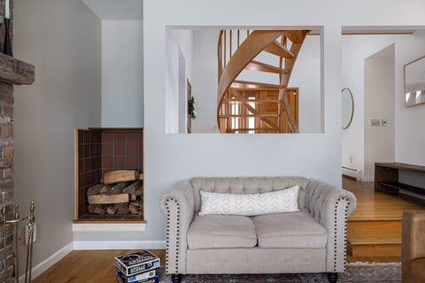 Living room features a supple leather sofa, tufted loveseat, and roomy chairs.