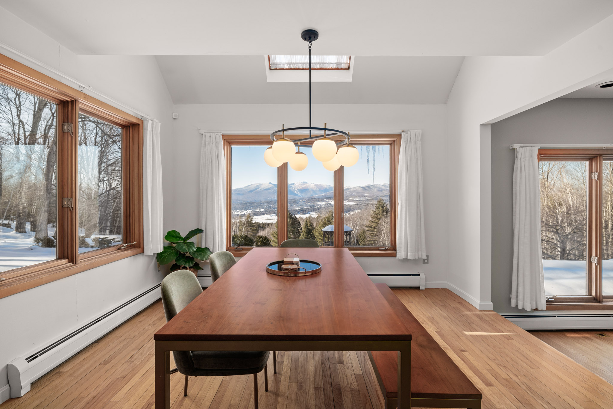 This warm dining area is connected to the kitchen and looks into the living room This warm dining area is connected to the kitchen and looks into the living room - Modern Retreat ~ Stunning Mountain View ~ Hot Tub! - Stowe