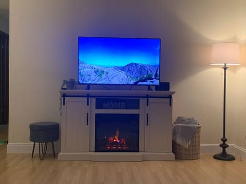 Smart TV with electric fireplace stand. Can be used with heat or just for ambiance.